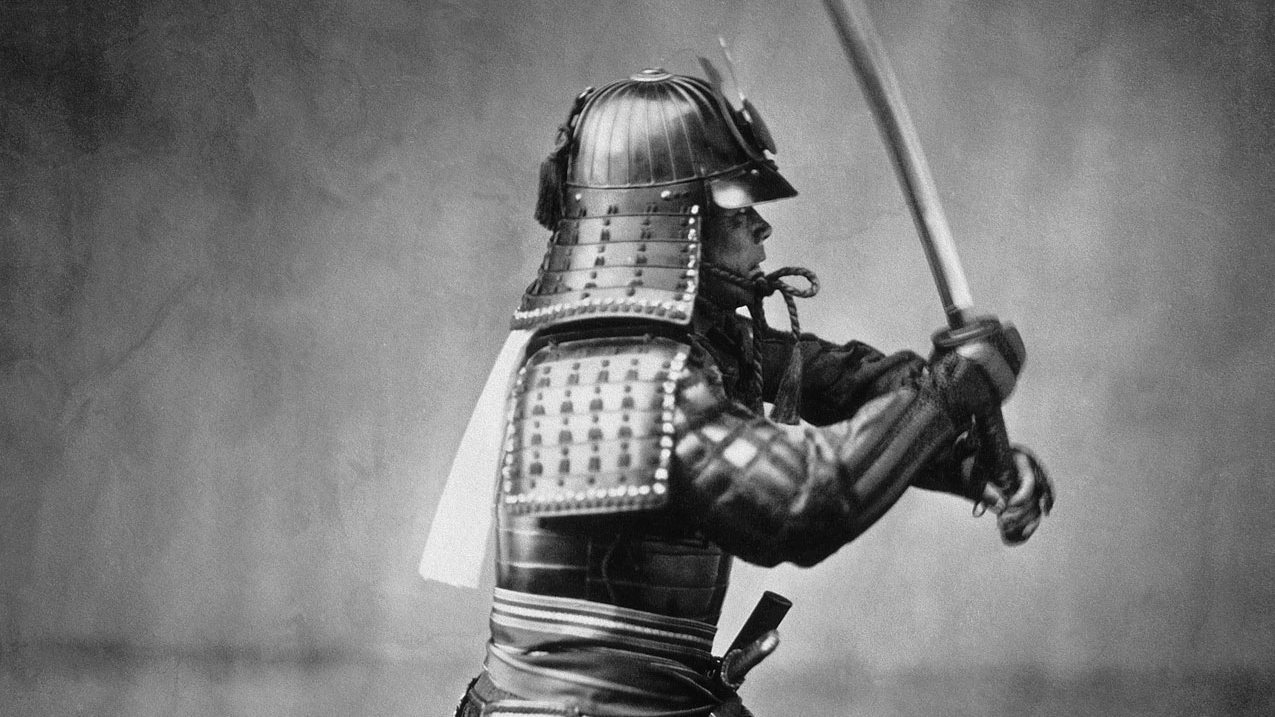 A samurai in full armor raising his sword, photographed around 1860.
