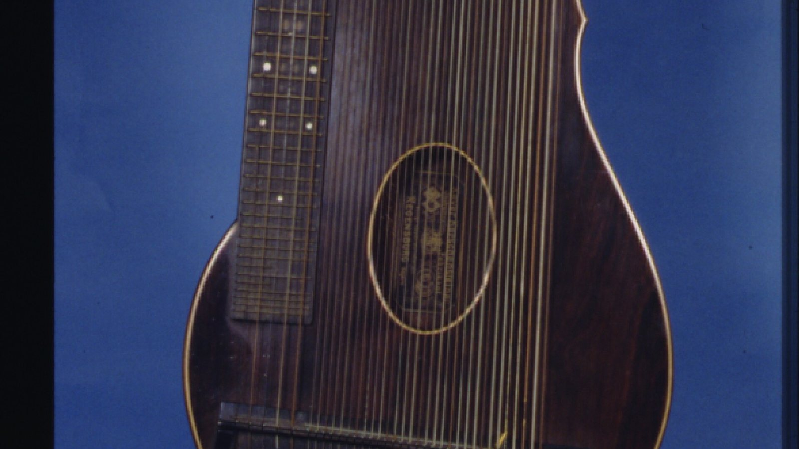 A mid-19th-century zither with thirty-five metal strings and a dark wooden body.
